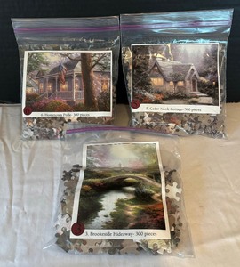 lot 236 image: Three 300 Piece Puzzles including Hometown Pride, Cedar Nook Cottage and Brookside Hideaway 300 Piece Puzzles