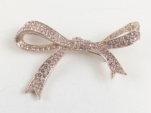 lot 217 image: Pink Rhinestone Ribbon Rose Gold Tone Base Metal Brooch .