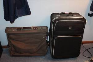 lot 105 image: American Tourister Brown Garment Bag and Leisure International Black Upright Suitcase