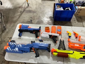 lot 57 image: TABLE FULL OF NERF & RIVAL GUNS