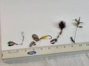 lot 234 image: Lot of Vintage Fishing Lures which include metal spinners, hooks with feathers, and one Pflueger