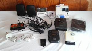 lot 12 image: Small Electronic Hand Variety, AMFM Stereo, Earbuds, Travel Adapters plus.
