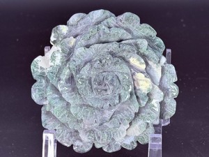lot 19 image: A hand-carved flower crafted from natural moss agate, showcasing intricate petal details and the stones unique green and earthy inclusions. 1 lb 6.7 oz.  0.644 kg.