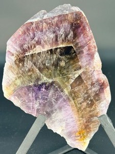 lot 23 image: A vibrant Super 7 slice showcasing the unique combination of seven powerful mineralsamethyst, cacoxenite, goethite, lepidocrocite, rutile, smoky quartz, and clear quartz.1 lb .9 oz.  0.480 kg.