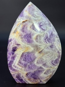 lot 28 image: A Chevron Amethyst Freeform is a beautiful, naturally shaped crystal that features striking V-shaped banding of deep purple amethyst and milky white quartz. Also known as Dream Amethyst, &nbsp3 lbs 1.4 oz.  1.401 kg.
