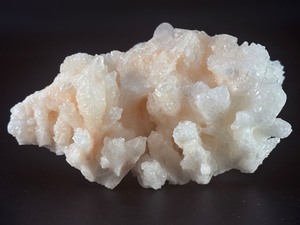 lot 35 image: Peach Stilbite is a delicate and captivating crystal known for its soft, peachy-pink color and intricate, fan-like formations. Often found in clusters, the crystals radiating, layered structures catch the light beautifully.&nbsp