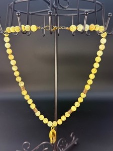 lot 38 image: This is a beautifully crafted piece that blends the warm, golden tones of honey calcite with symbolic spiritual energy. The Gyan Mudra hand charm representing wisdom and spiritual connection.