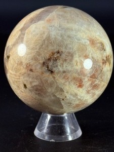 lot 47 image: Moonstone Sphere with Blue Flashes is a captivating crystal sphere known for its soft, luminous glow and stunning blue flashes that shimmer as the light moves across its surface.1 lb 1.9 oz.  0.509 kg.