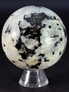 lot 63 image: Rainbow Moonstone Sphere is a luminous and enchanting crystal sphere known for its soft glow and mesmerizing flashes of blue, rainbow, and pearly light that shimmer as it moves.&nbsp1 lb 0.9 oz.  0.481 kg.