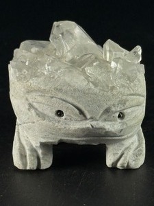 lot 83 image: Hand-Carved Quartz Frog Cluster is a charming and energetically vibrant crystal piece, expertly carved into the shape of a frog while preserving the natural beauty of the quartz cluster. 6.1 oz.  0.174 kg.