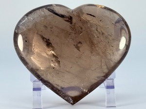 lot 84 image: Large Smoky Quartz Heart with Rainbows &amp Inclusions is a striking, hand-polished crystal heart. The rich, earthy tones of smoky quartz along with natural internal inclusions that create captivating rainbows. 2 lbs 6.2 oz.  1.085 kg