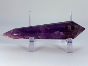 lot 86 image: Extra Large Amethyst Vogel Double Terminated is a powerful and visually striking crystal, expertly carved into the iconic Vogel shape with pointed terminations at both ends.12.3 oz.  0.350 kg.
