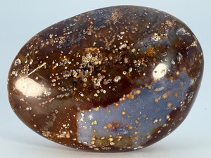 lot 89 image: Orbs Ocean Jasper Palm Stone is a smooth, hand-polished crystal shaped to fit comfortably in the palm, showcasing the signature orb-like patterns and soothing earthy tones of ocean jasper. 1 lb 2.6 oz.  0.530 kg.