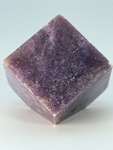 lot 90 image: Lepidolite Cube with Flat Corner is a uniquely shaped crystal that combines the natural beauty of lepidolite with a geometric form. 10.8 oz.  0.309 kg.