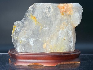 lot 1 image: &nbspA radiant Golden Healer quartz that shimmers with warm, honey-gold hues and soft natural phantoms. &nbspwith custom wooden stand from Brazil. 4 lbs 1.3 oz.  1.852 kg.