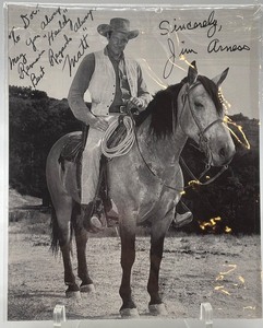 lot 111 image: Autographed Jim Arness Black and White Mounted Horse Photograph