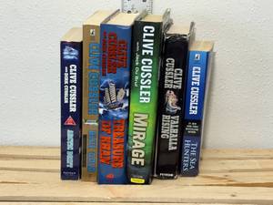 lot 11-F2025 image: 6 Clive Cussler books, 3 soft cover books, 3 hardcover our treasure of KHAN, mirage, Valhalla rising, soft cover, Arctic drift, blue gold, the sea hunters