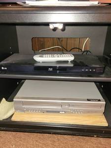 lot 317 image: Cabinet with LG Blu-ray Player and Sylvania DVD Player with Remote Controls