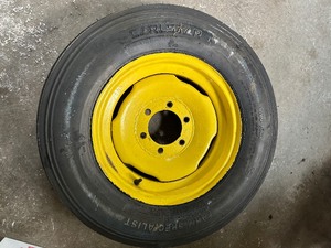 lot 169 image: One Yellow Rimmed John Deere Front Tractor Tire and Second John Deere Tire