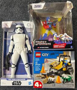 lot 44 image: Star Wars Stormtrooper Action Figure, Transformer Optimus Pride and LEGO City Road Work Truck