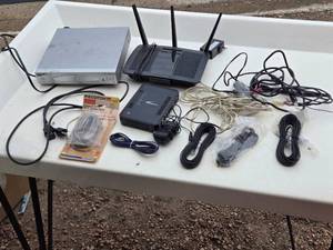 lot 40 image: DVD player, a wireless router, a modem, and various cables and accessories