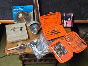 lot 193 image: Lot of Various Tools and Accessories such as drill bits in orange cases, a Makita carbide-tipped saw blade, a magnetic wristband, and several small hand tools and accessorie