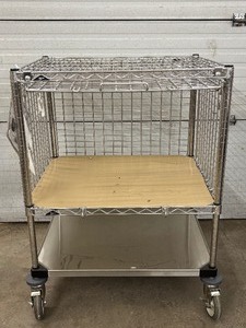 lot 43 image: Metro 3-Tier Mobile Wire Utility Cart with Smooth Rolling Casters, Durable Metal Frame, and Open Shelf Design for Easy Access. Appear To Be A Cage Like System On Top With Slide Up Door