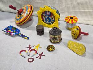 lot 74 image: Lot of Vintage Tin Toys and Novelty Items - Magic Mirror, spinning top, a clock with cartoon illustrations,magnetic figures, Cracker Jack Horseshoe Magnets, and other small playful items