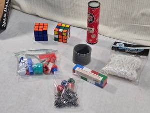 lot 77 image: Lot of Vintage Puzzles, Toys, and Sports Accessories includes two Rubiks cubes, a kaleidoscope, a basketball net, and a set of 1960s Instant Insanity blocks