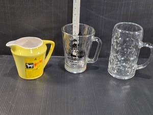 lot 173 image: White Horse Scotch Whisky water pitcher, a Tuborg Gold glass mug with a Viking design, and a clear glass beer mug