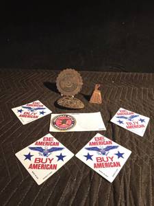 lot 190 image: Vintage 40 yr brass calendar (1974-2013), copper cow bell, defender of freedom belt buckle, NRA stickers and 4 Be american Buy American window signs