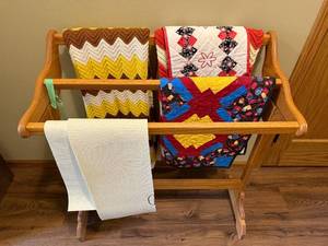 lot 407 image: Wooden Quilt Rack with Assorted Patterned Quilts & A Knit Throw