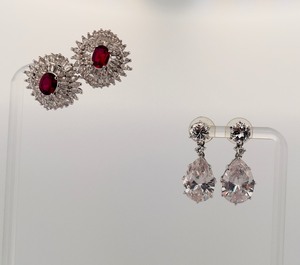 lot 286 image: 2 pierced earrings, one pear cut dangle post,  stud with red gemstone center surrounded by rhinestones