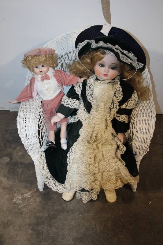 lot 74 image: Set of 2 Porcelain Dolls on Wicker Chair