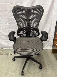lot 20 image: MSRP $1250 Herman Miller Mirra 2 Chair  Experience next-level comfort with this ergonomic powerhouse. Offers flexible support, smooth recline, and a unique Loop Spine for perfect posture all day long. Ideal for serious work and style.