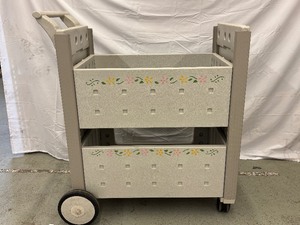 lot 25 image: Molded Book Cart featuring a charming flower design With two roomy shelves and sturdy construction, its perfect for organizing books, toys, or supplies in style. Good condition and ready to add a fun touch to any room