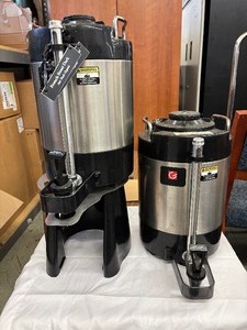 lot 52 image: Set of 2 Grindmaster VS-1.5A 1.5 Gallon Coffee Shuttles with Stand  Stainless Steel, Vacuum Insulated Serve fresh, hot coffee for hours with these commercial-grade brewers. Brew-thru lids, compact design, and included stand make pouring fast and easy