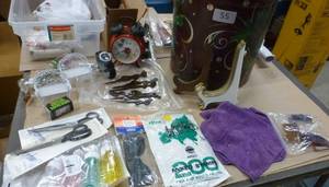 lot 55 image: Can full of whatever fits - clock, scissors, stamps, watch, microfiber cloth, plate stands, vacuum bags