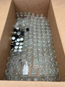 lot 15 image: Box of Glass Jars - 3.25 Inches tall and 1.5 inches wide, Some have screw caps, most dont