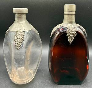 lot 59 image: Vintage Uranium Glass 3 Sided Pinch Glass Liquor Bottle with Pewter Details & Vintage Red 2 Sided Dimpled Glass Bottle with Pewter Details