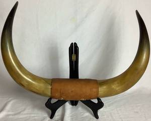 lot 14 image: Vintage Pair of Aged Patina Bull Horns Joined by a Leather Piece in the Center