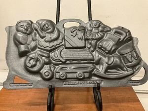 lot 34 image: 1986 John Wright, A Sleigh Full O Toys Cast Iron Baking Pan
