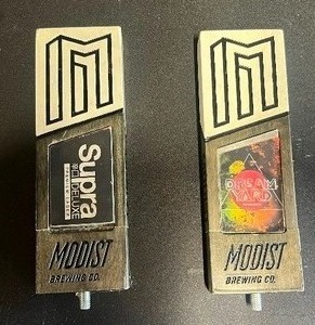 lot 95A image: Two Tap Handles from Modist Brewing Co., Featuring Two of Their Beers Supra Deluxe Premium Lager and Dream Yard
