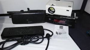 lot 110 image: GE Clock Radio, RCA Projector, Sony Wireless Speaker (Powers On) and more.