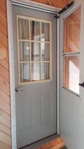 lot 147 image: Cabin Tear-down 32 in. Exterior Doors (4) Windows (2) and Wood paneling.
