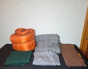 lot 214 image: Assorted Bedding Collection Including Weighted Blanket, Sleeping Bag, and Throws