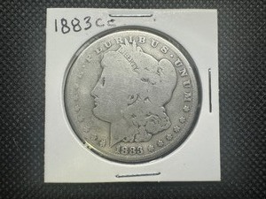 lot 16 image: 1883 CC Better Date Carson City Morgan Dollar. Authentically well worn. The market is flooded with fakes, this is not one of them