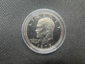 lot 18 image: 1973 S Gem Proof Eisenhower Dollar in capsule. Clad, deep mirrors, essentially flawless