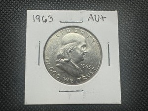 lot 22 image: 1963 Au Franklin Half Dollar. Actually, a BU with very slight wear at the bottom of the bell. Visible only through the scope.