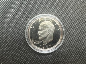 lot 48 image: 1977 S Gem Proof Eisenhower Dollar in Capsule. Clad, deep mirrors, essentially flawless.